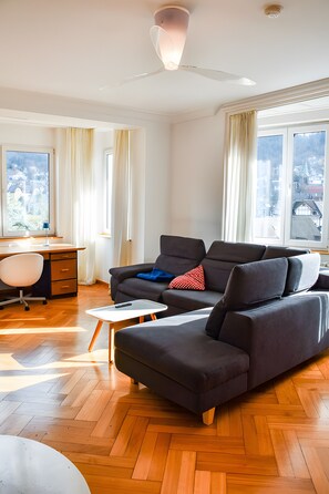 Een moderne woonkamer met een bank, een bureau en een stoel.
