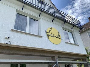 A building with a balcony and a sign that reads 'link.' - Holiday flat "Villa Fink Obergeschoss" with mountain view, private terrace and wifi. (Schramberg)