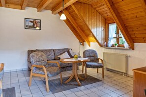 A cozy room with a wooden ceiling, a sofa, two chairs, a small table, and a picture on the wall. - Apartment Afterglow (Oberried-St. Wilhelm)