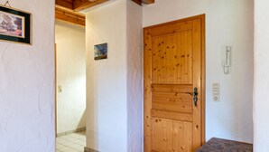 A hallway with a wooden door, a small bench, and a telephone on the wall. - Apartment Afterglow (Oberried-St. Wilhelm)