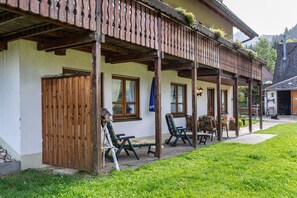 A building with a wooden balcony, outdoor seating, and a garden area. - Apartment Wiesengrund (Oberried-St. Wilhelm)