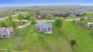 An aerial view of a residential area with houses, green lawns, and a clear sky. - Galena 4BR • 4 Private Baths • Sleeps 10 • Game Room • Owners’ Club (Galena)