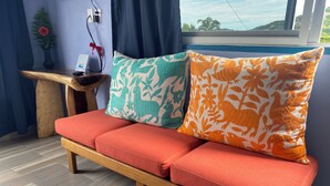 Un banc en bois avec des coussins rouges et deux oreillers à motifs.