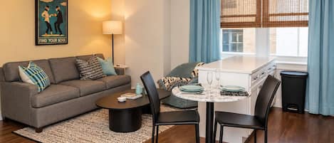 A modern living room with a sofa, coffee table, and dining area.