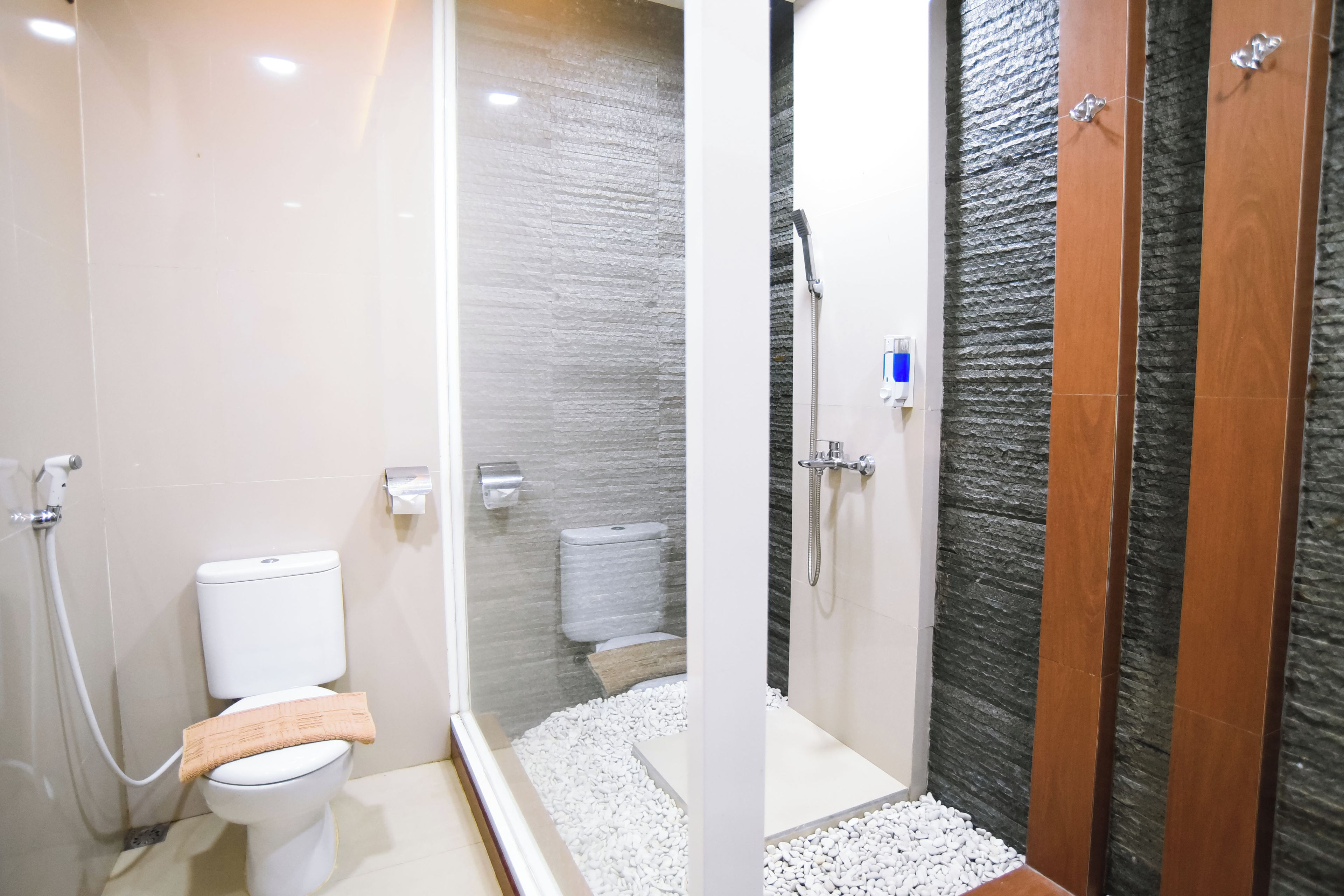 Un baño moderno con inodoro, ducha y mampara de vidrio.