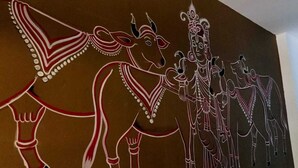 A wall with a large, colorful mural of figures and animals. - BRAJDHAM HOTEL BARSANA (Chhata)