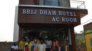 A group of people standing in front of Brij Dham Hotel AC Room. - BRAJDHAM HOTEL BARSANA (Chhata)