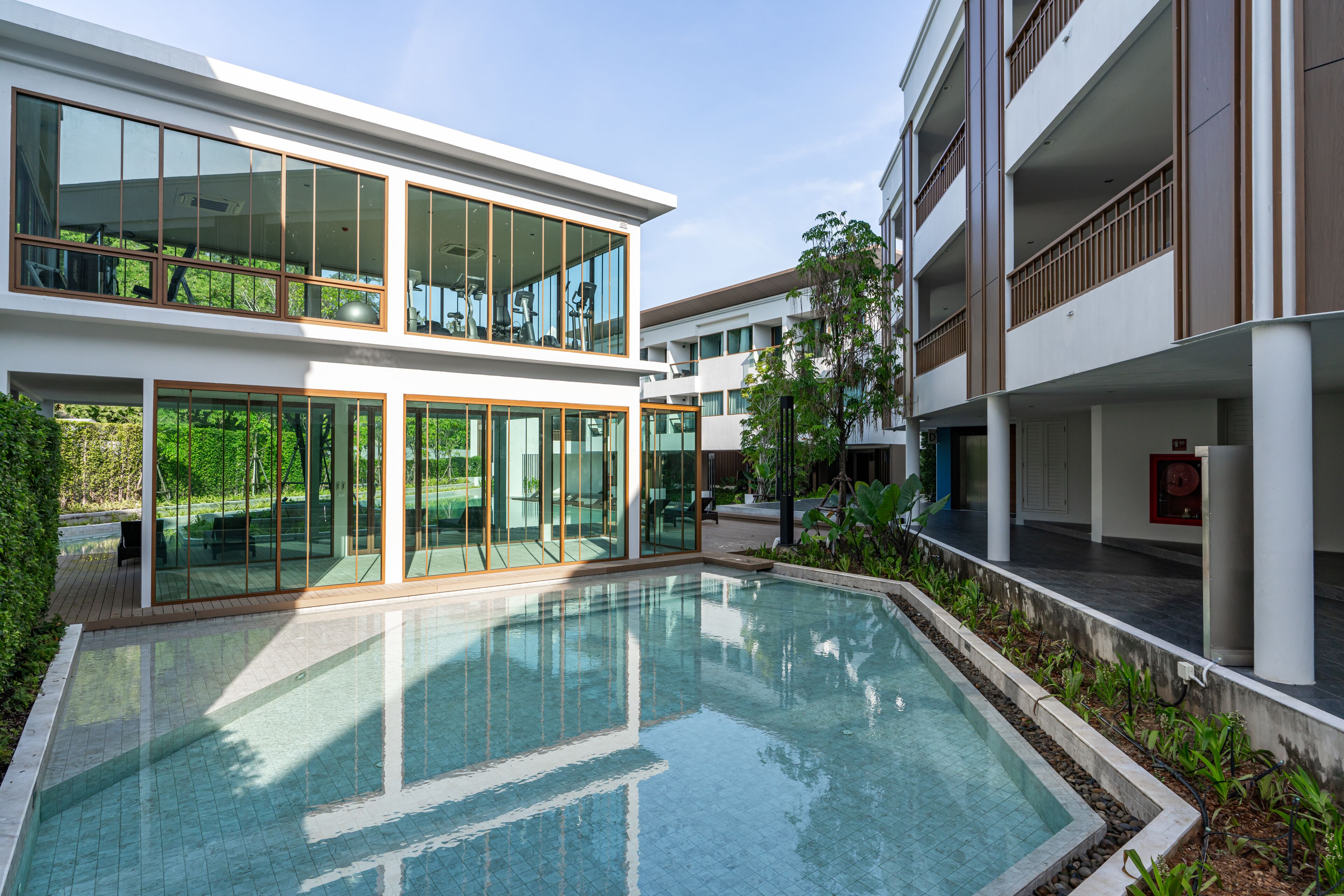 A modern building with a swimming pool, large windows, and a balcony.