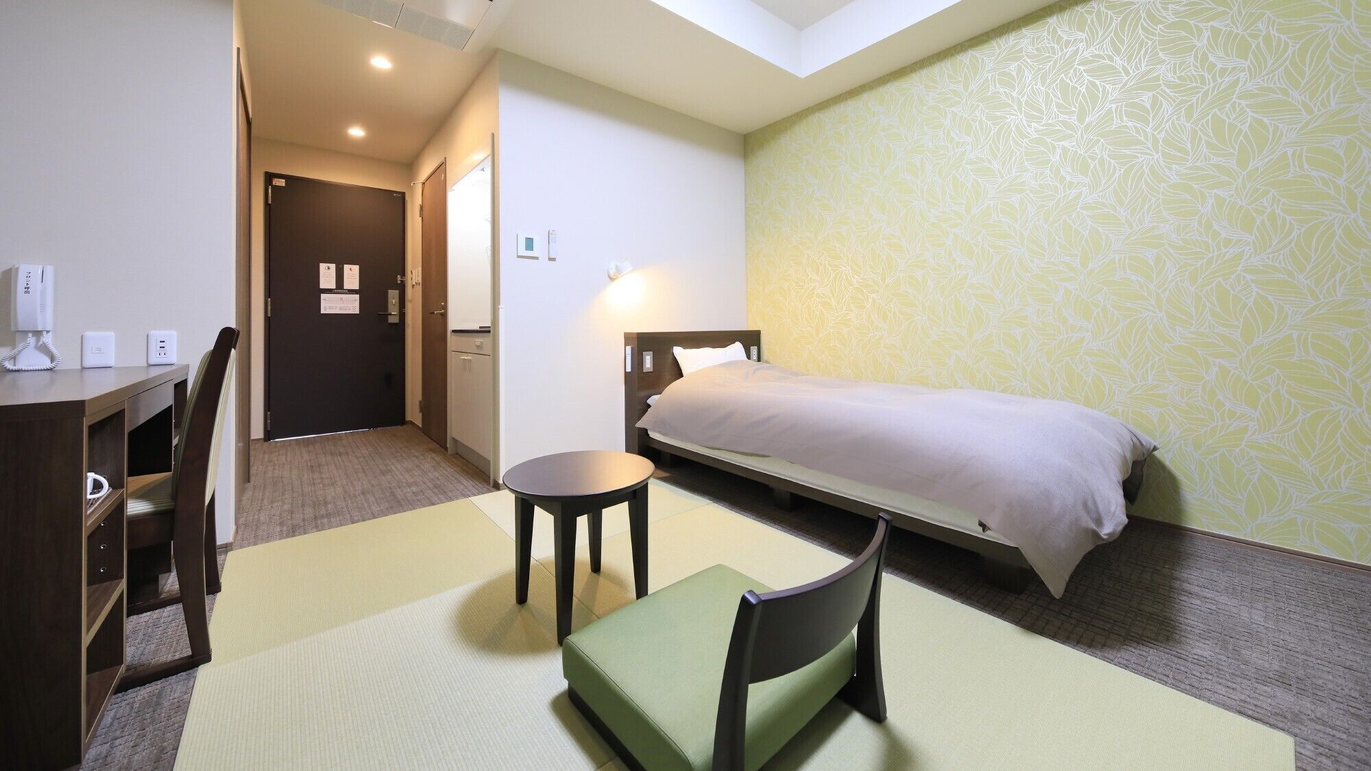 Une chambre d’hôtel comprenant un lit, un bureau, une chaise, une petite table et un canapé.