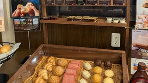 Une variété de produits de boulangerie présentés dans une boîte en bois, sur laquelle est apposée une étiquette indiquant « PAIN DE STYLE ».
