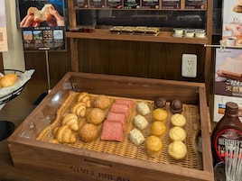 Exposição de diversos pães e produtos de panificação numa caixa de madeira com a etiqueta 'STYLE BREAD'.