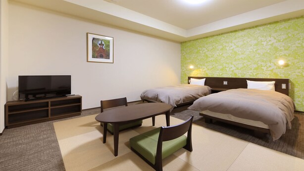 Una habitación de hotel con cama, televisión, mesa y sillas.