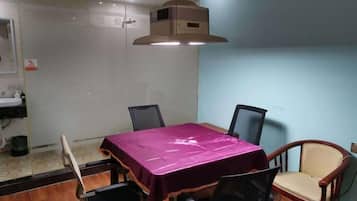 A conference room with a table, chairs, and a ceiling-mounted air conditioning unit.