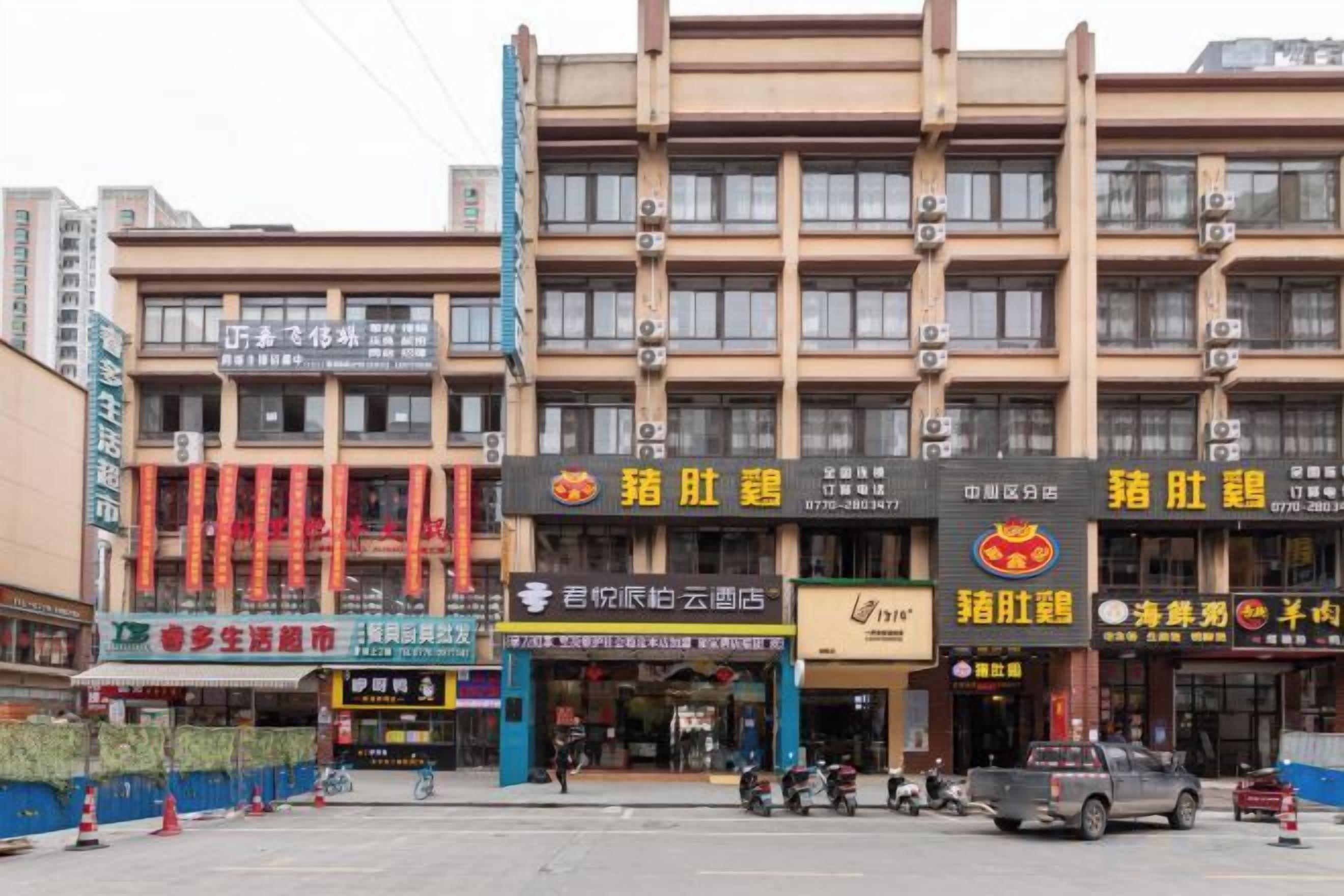 A multi-story building with various commercial establishments on the ground floor, including restaurants and shops.