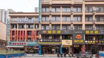 A multi-story building with various commercial establishments on the ground floor, including restaurants and shops.