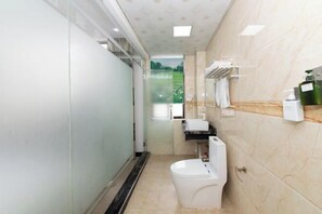 Un baño moderno con inodoro, lavamanos y zona de ducha.