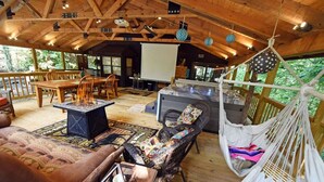 Un rincón salón acogedor con suelo de madera, una chimenea, asientos cómodos y una hamaca.
