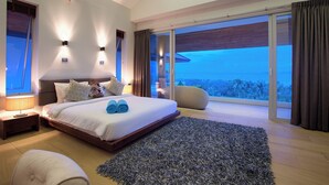Una camera da letto moderna con un letto grande, vista sull'esterno e un balcone.