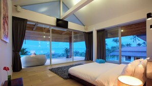 Una camera da letto moderna con un letto grande, vista all'esterno e una porta scorrevole in vetro che dà su un balcone.