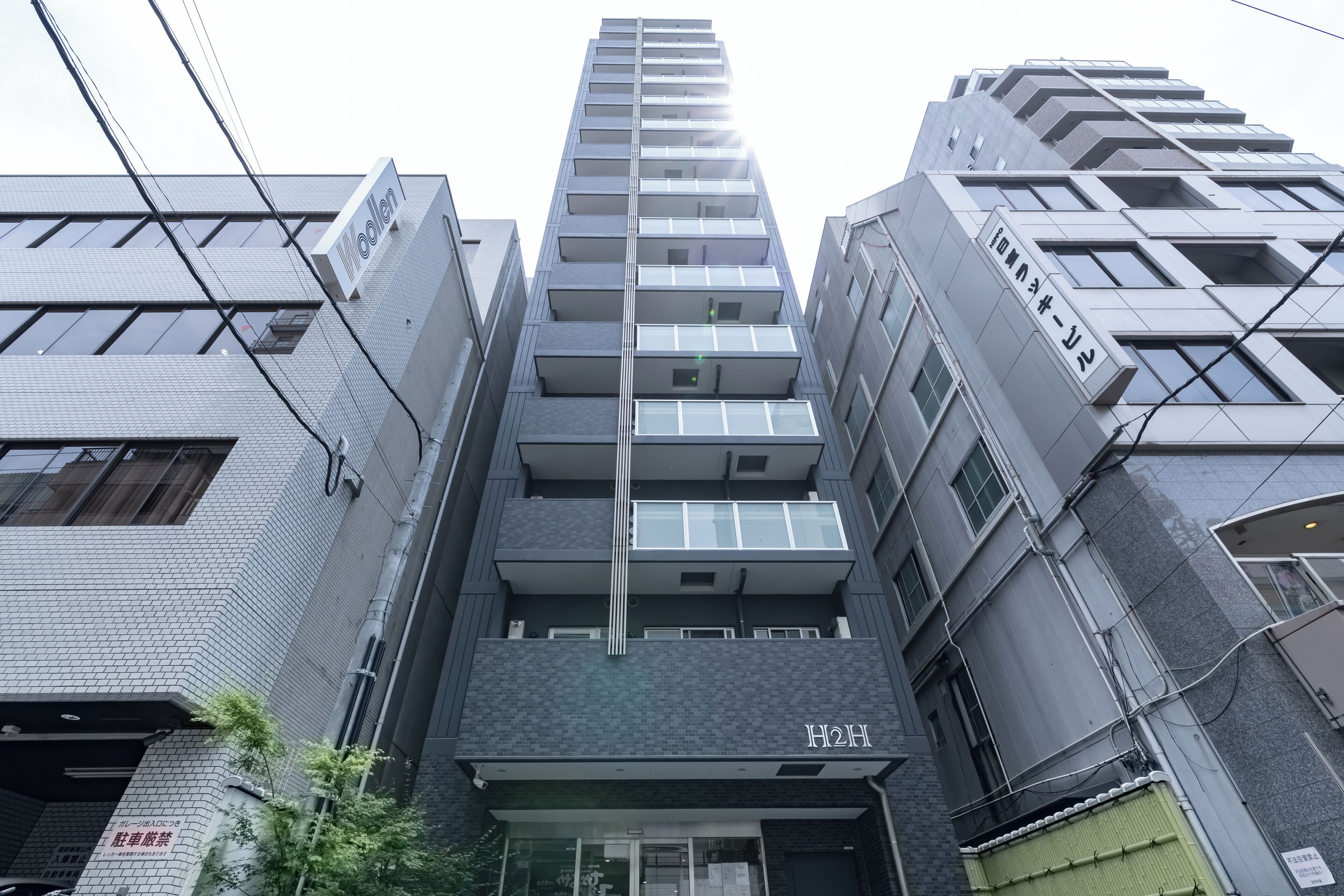 Un moderno edificio de gran altura con múltiples balcones y amplios ventanales.