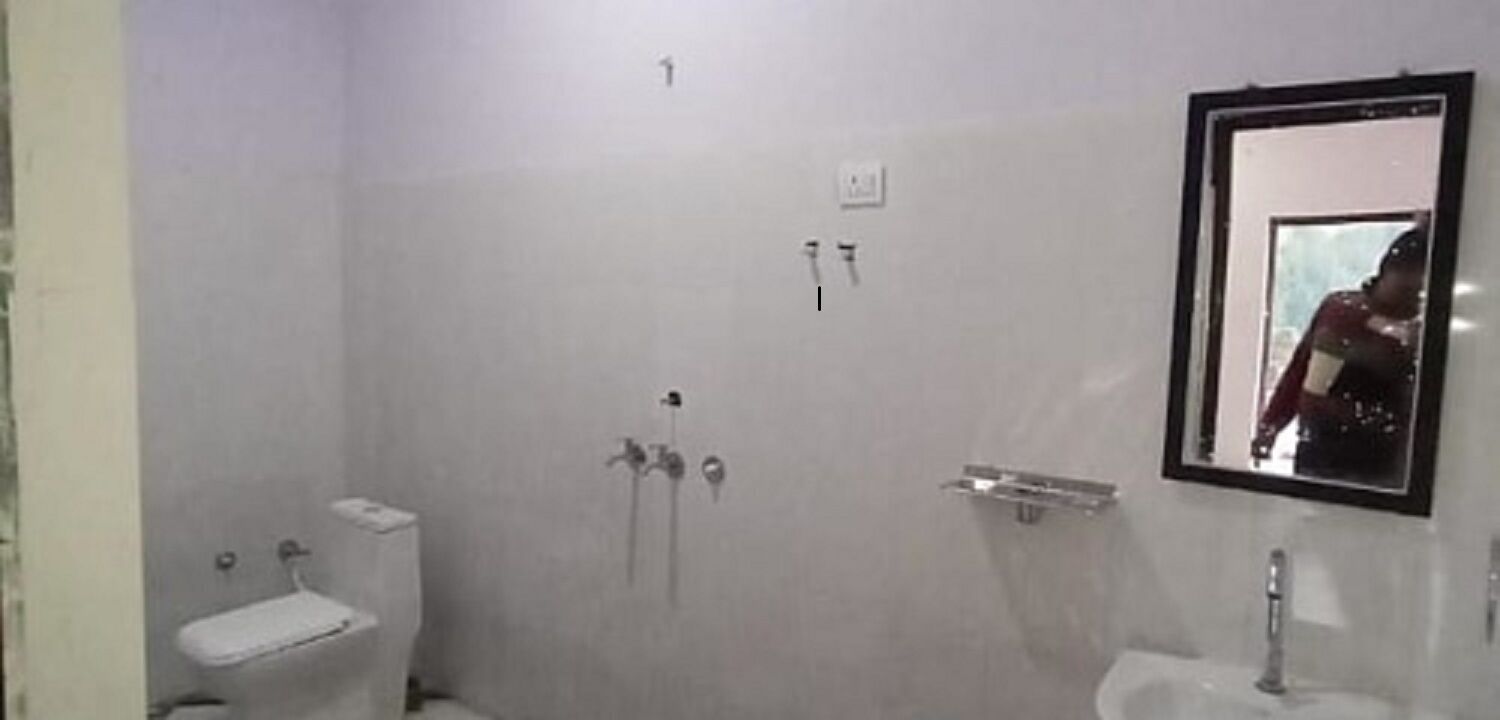 A bathroom with a toilet, sink, and shower.