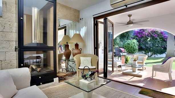 Un salon moderne avec une table basse en verre, un canapé et une cheminée.