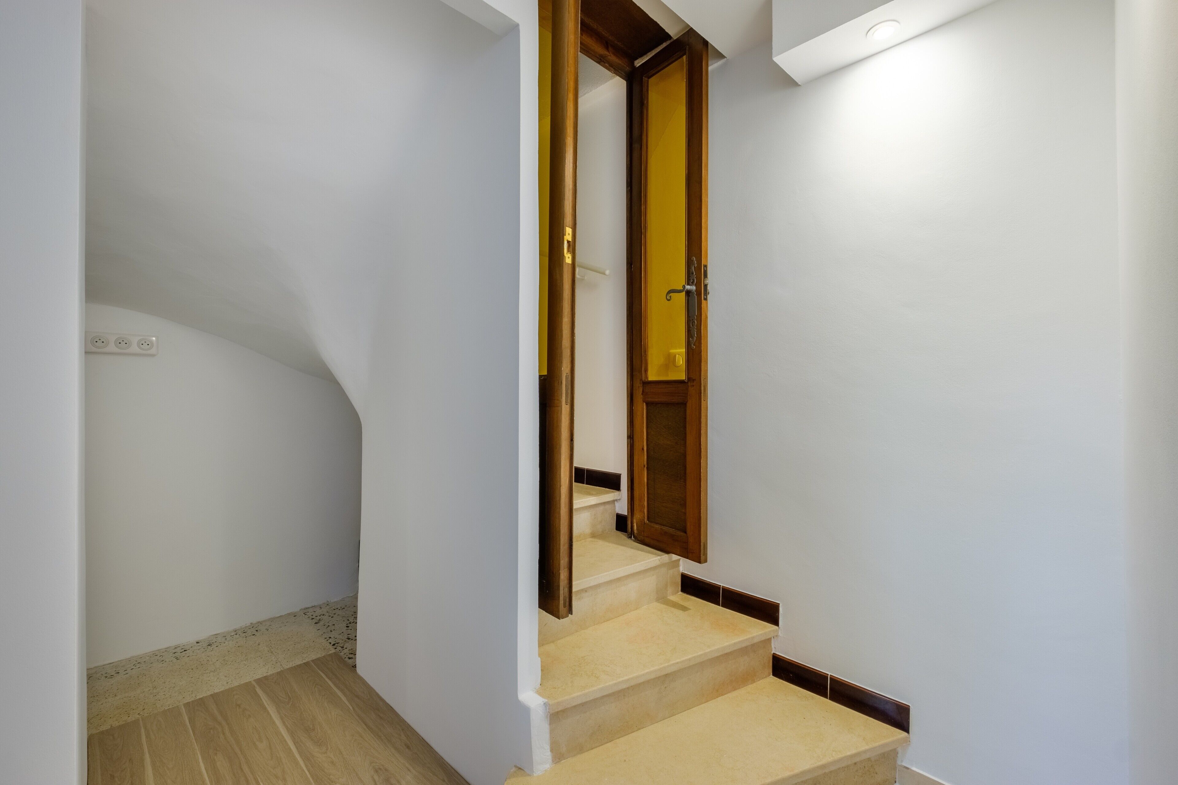 Een trap met een houten deur naar een kamer.