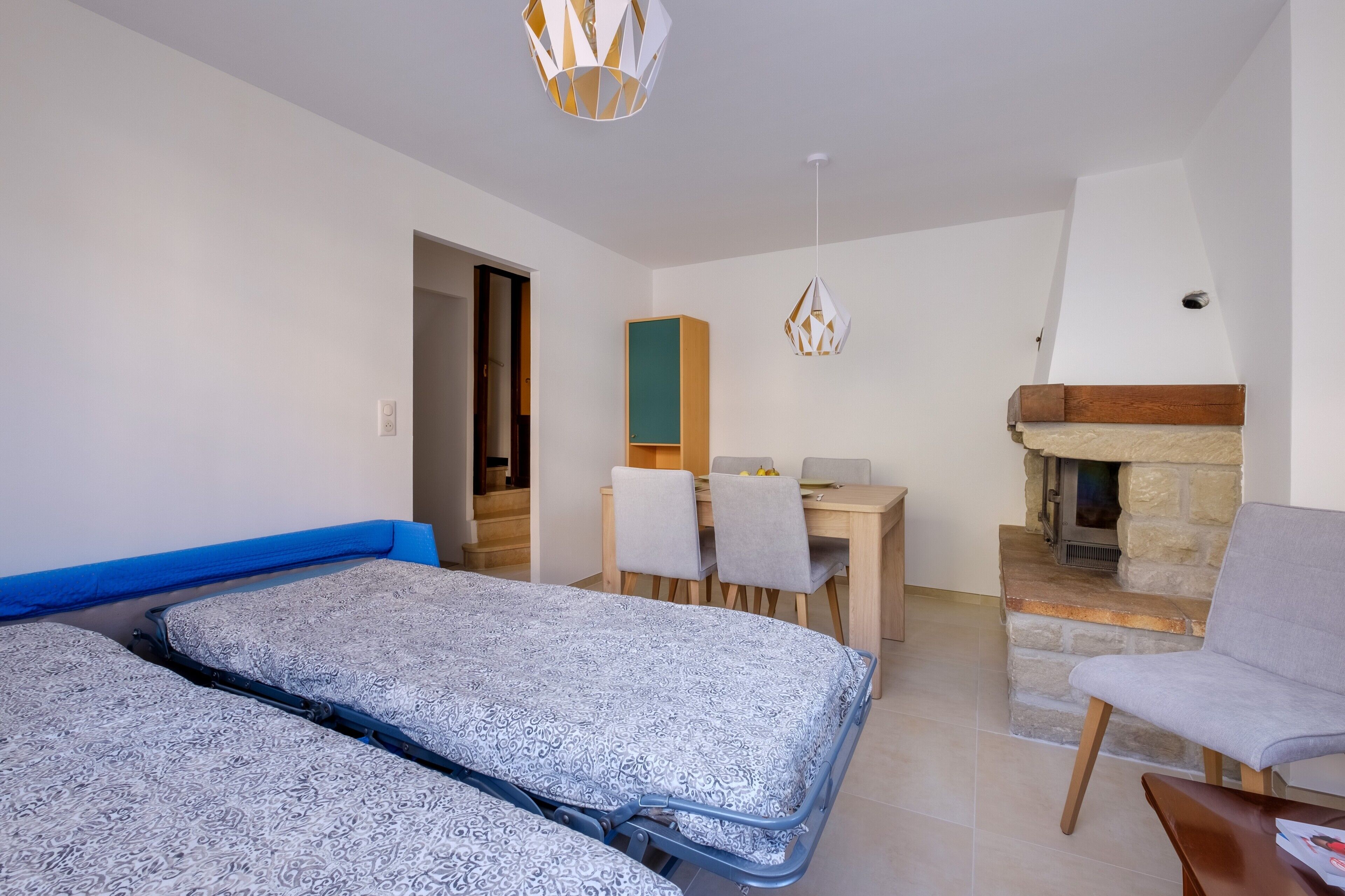 Ein Schlafzimmer mit einem Bett, einem Schreibtisch, einem Sessel und einem Kamin.