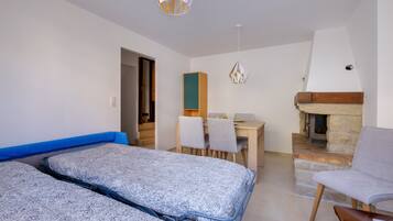 Ein Schlafzimmer mit einem Bett, einem Schreibtisch, einem Sessel und einem Kamin.