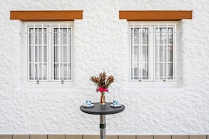 A white textured wall with two windows, each with white bars and brown window sills. - Holiday Home "Sweet Home Madeira" with Sea View, Private Terrace & Wi-Fi (Camacha)