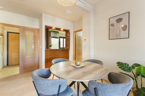 A modern dining area with a round table, six grey chairs, a central decorative bowl, and a large plant. - Holiday Apartment "El Oasis Malasia 16 Bajo A" with Shared Pool, Private Terrace & Wi-Fi (Fuente Álamo)