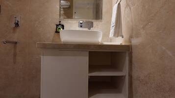 Deluxe kamer | Badkamer | Een douche, handdoeken, zeep, shampoo