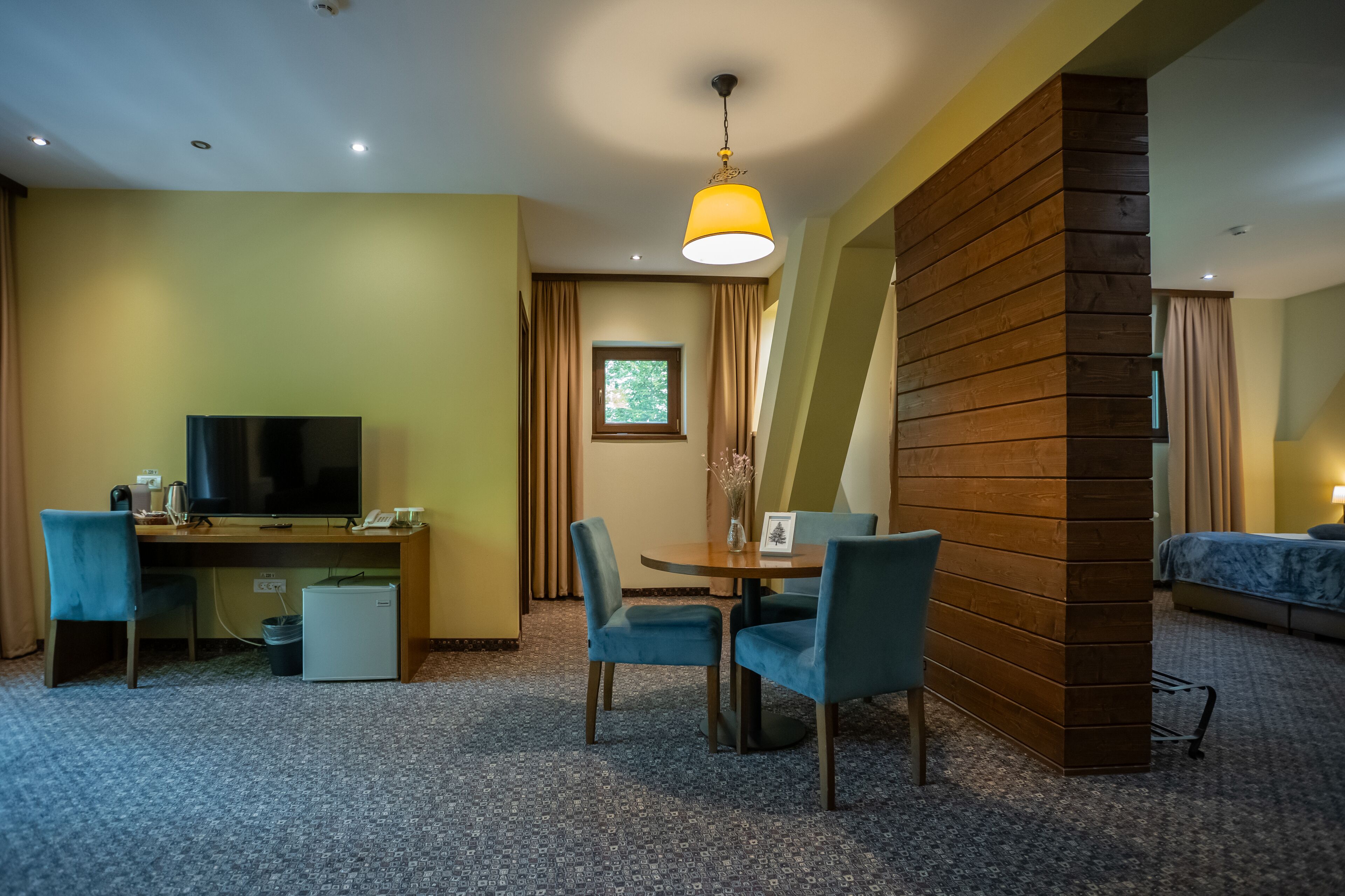 Habitación de hotel con escritorio, televisión y zona de estar.
