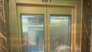 Un ascensor con interior metálico y un cartel que dice 'LIFT'.