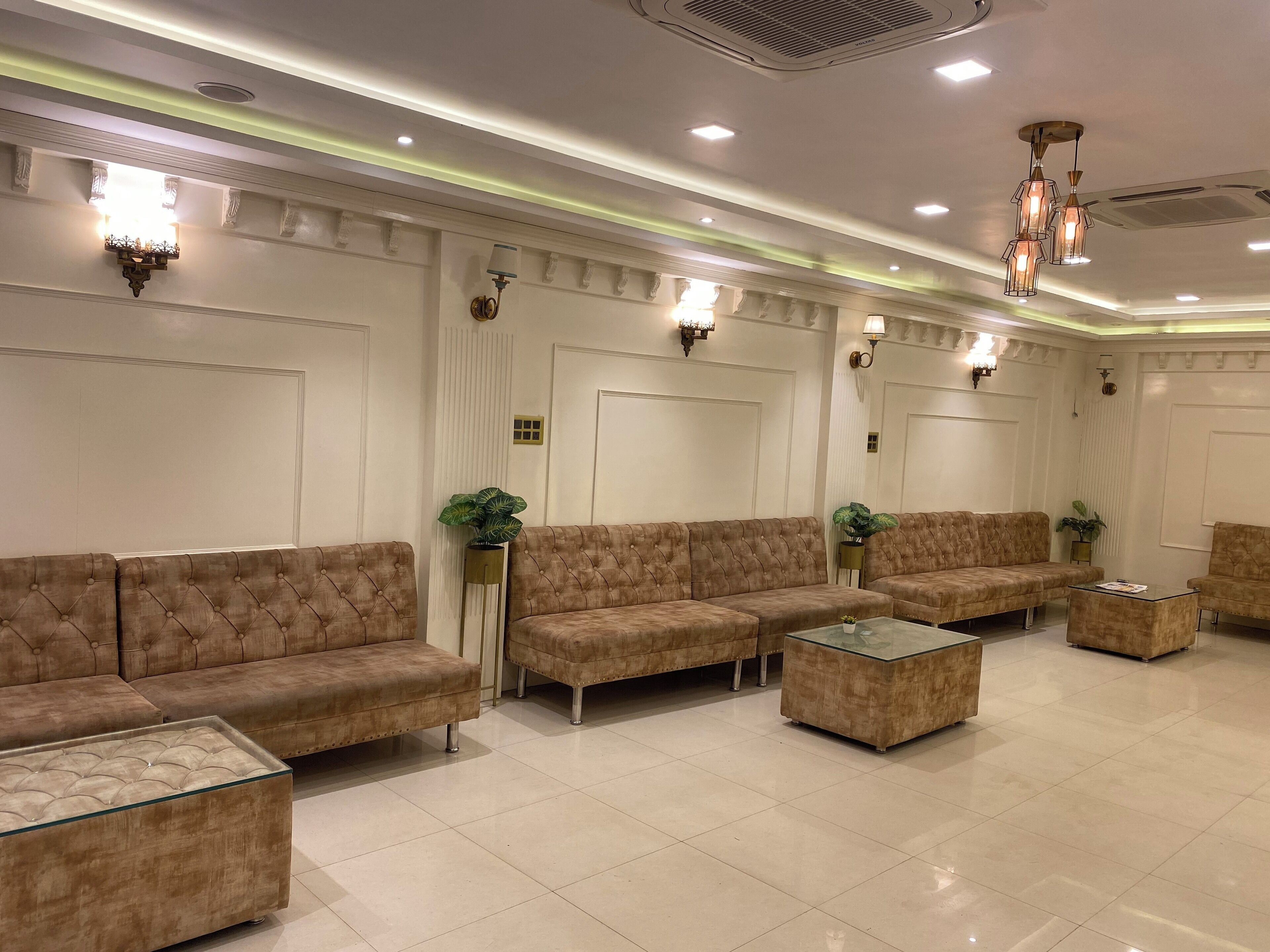 A spacious lobby with a modern design, featuring a large seating area with sofas and a glass coffee table.