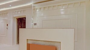 Un pasillo con paredes blancas y una puerta que da a otra habitación.