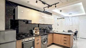 Une cuisine moderne équipée d’un réfrigérateur, d’une cuisinière, d’un four et d’un lave-linge.
