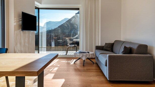 Uma sala de estar moderna com um sofá, uma mesa e uma televisão.