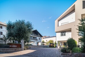 A modern building with a sign reading 'Karin Ferienwohnungen.' - Holiday Apartment 'Karin - Gala' with Shared Terrace and Wi-Fi (Termeno)