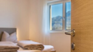 A bedroom with a bed, a window, and a door. - Apartment "Karin - Golden" with Shared Terrace and Wi-Fi (Termeno)