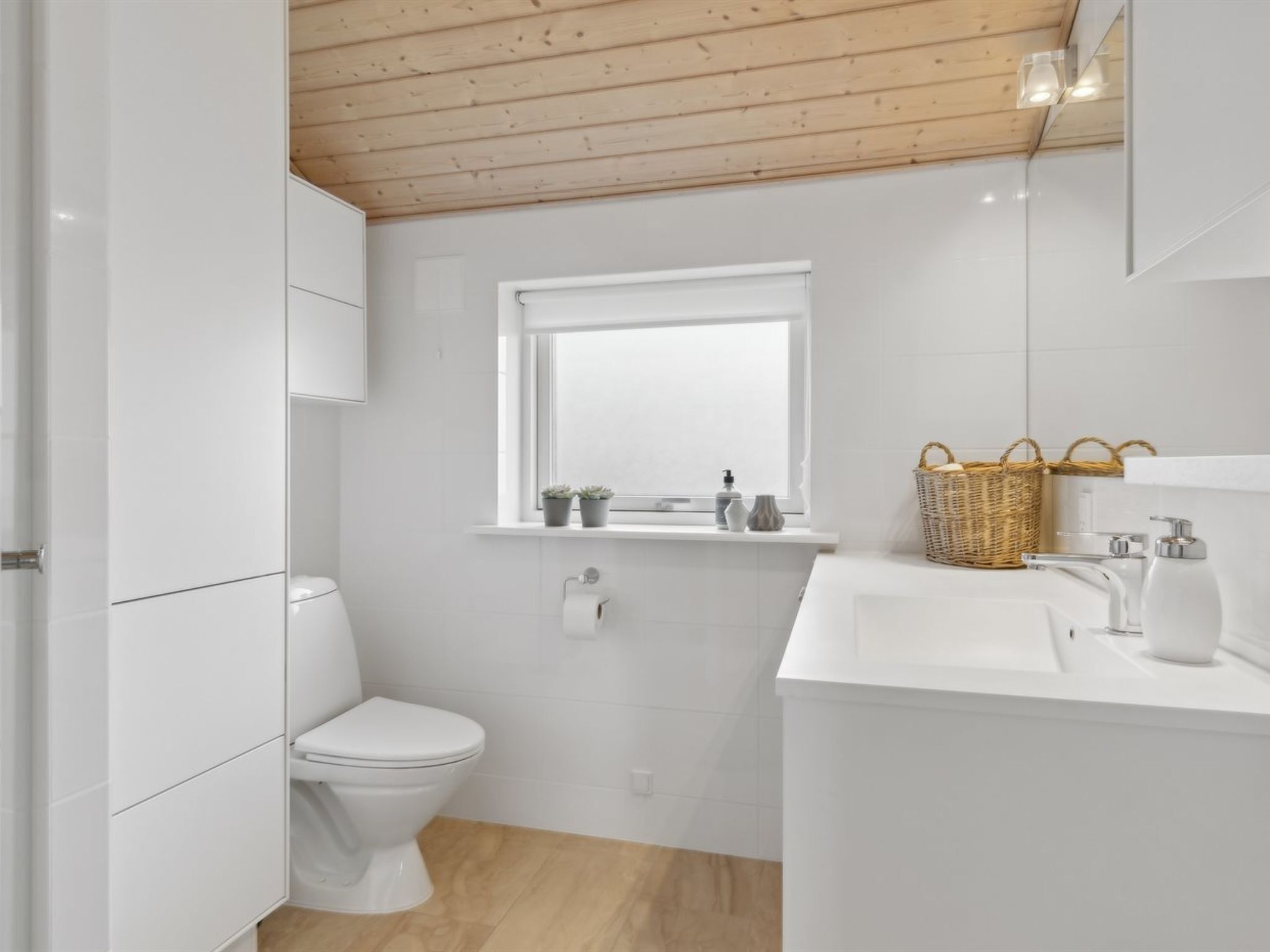 Une salle de bain moderne avec des toilettes, un lavabo et une fenêtre.