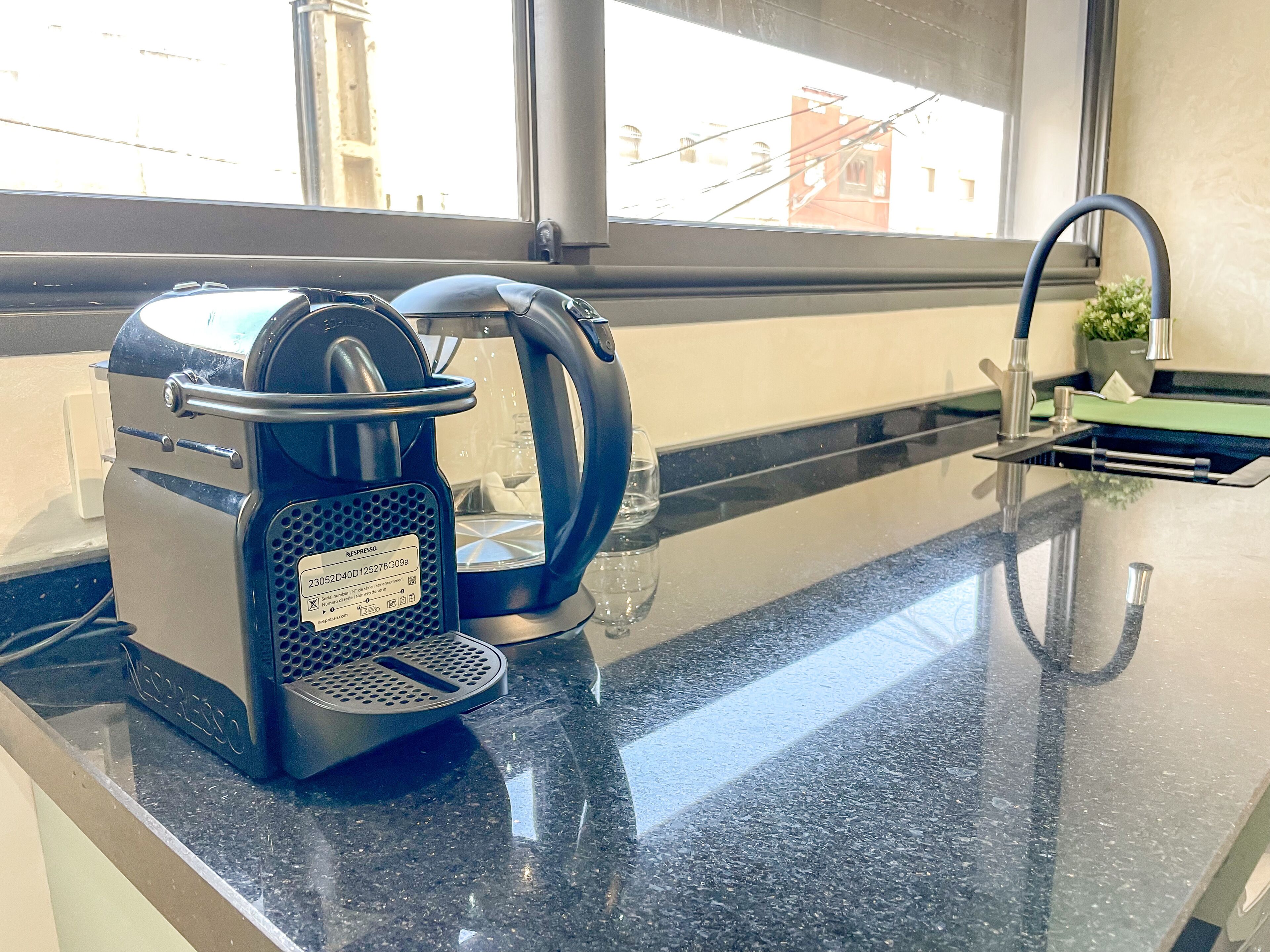 A Nespresso coffee machine on a kitchen counter with a window view.