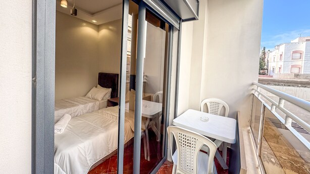 A balcony with a bed, a table, and chairs. - El-wifaq - Appartement 2 (Agadir)