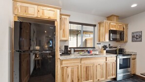 Une cuisine moderne avec des meubles en bois, des appareils en acier inoxydable et un plan de travail en granit.