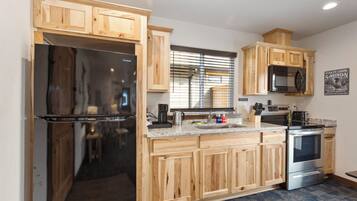 A modern kitchen with wooden cabinets, stainless steel appliances, and a granite countertop.