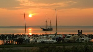 Ein Yachthafen mit vor Anker liegenden Booten, ein friedlicher Sonnenuntergang und ein klarer Himmel.