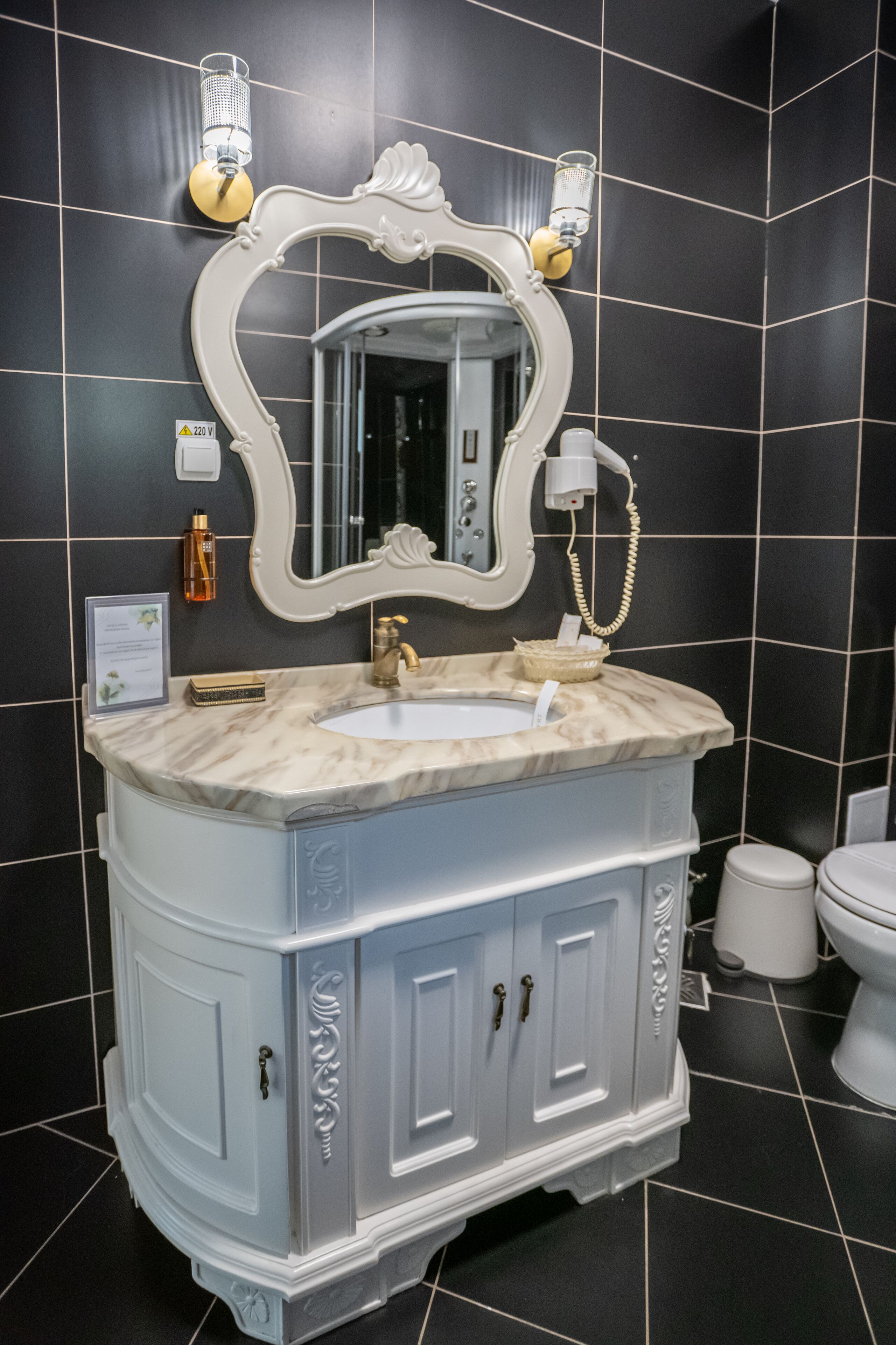 Un baño con tocador blanco, un espejo grande y un inodoro blanco.