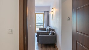 Un pasillo que da a una sala de estar con sofá y ventana.