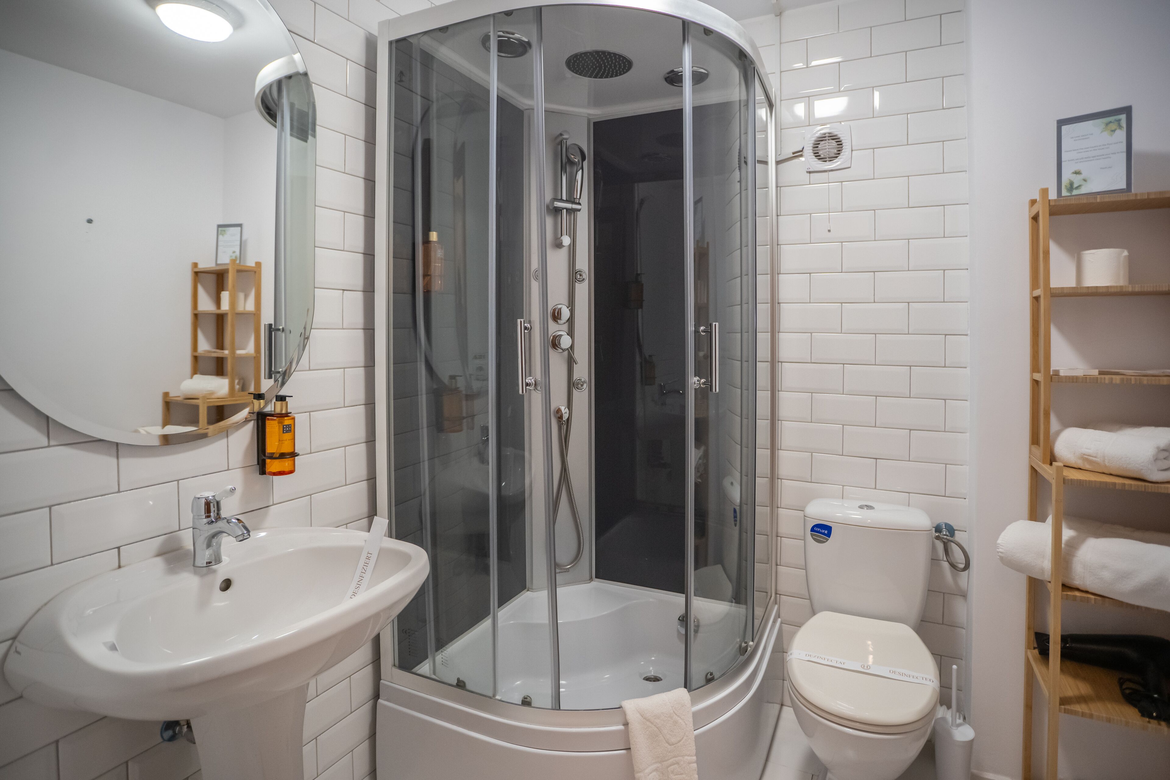 A modern bathroom with a glass-enclosed shower, a sink, and a toilet.