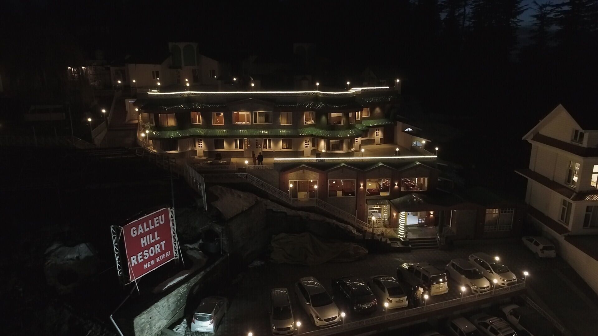 Ein mehrstöckiges Hotel mit einem Schild für das Galleu Hill Resort in New Kufi.